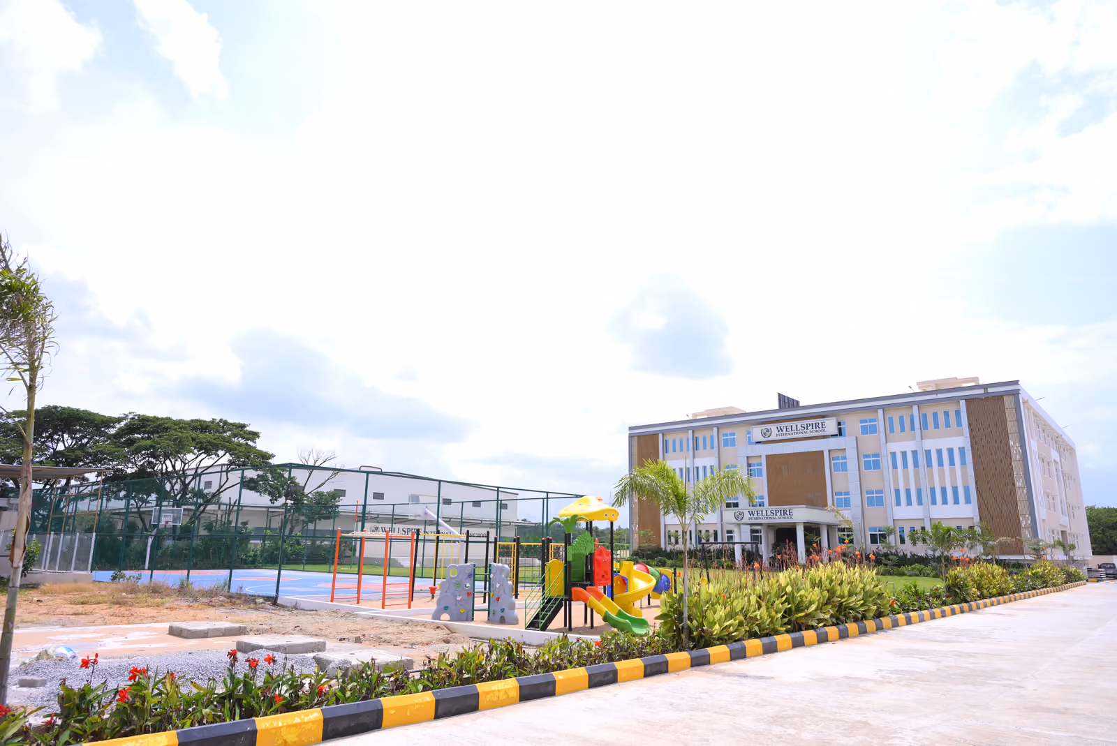 Wellspire School main building with playground and outdoor sports court