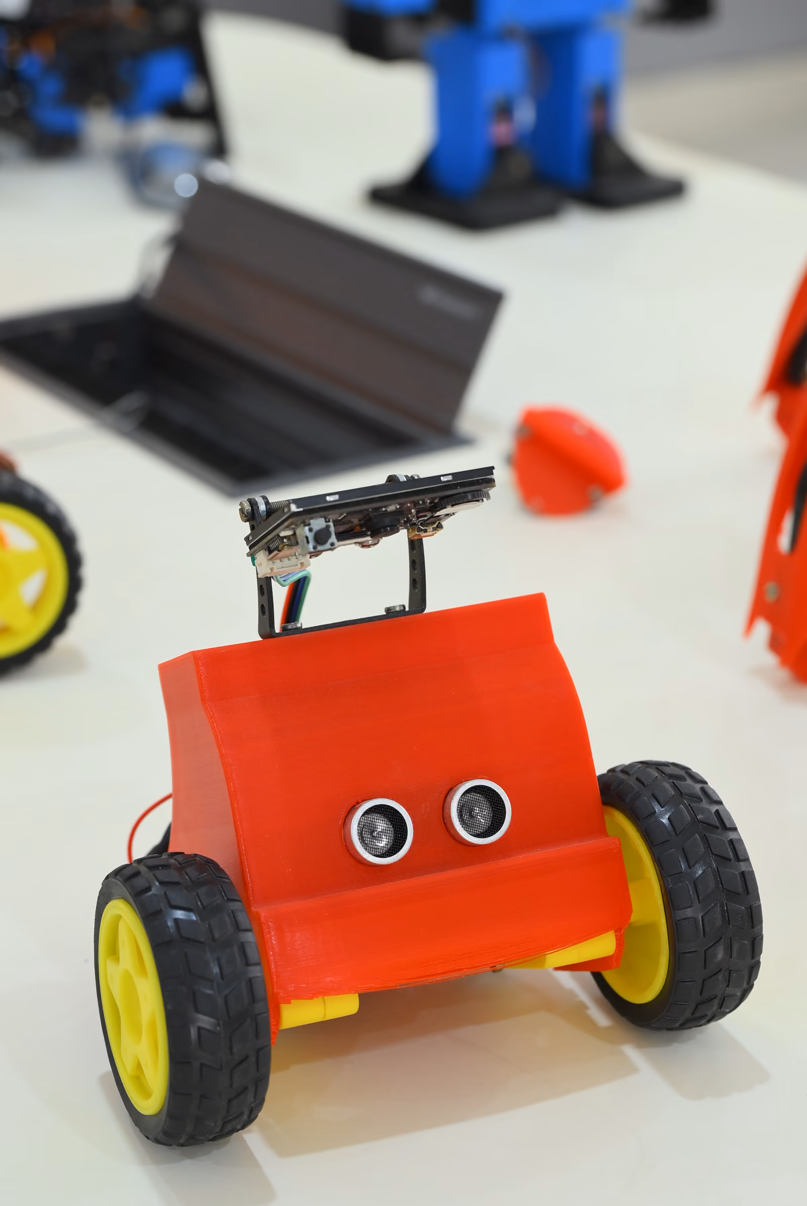 Small wheeled educational robot with sensors on a white lab table