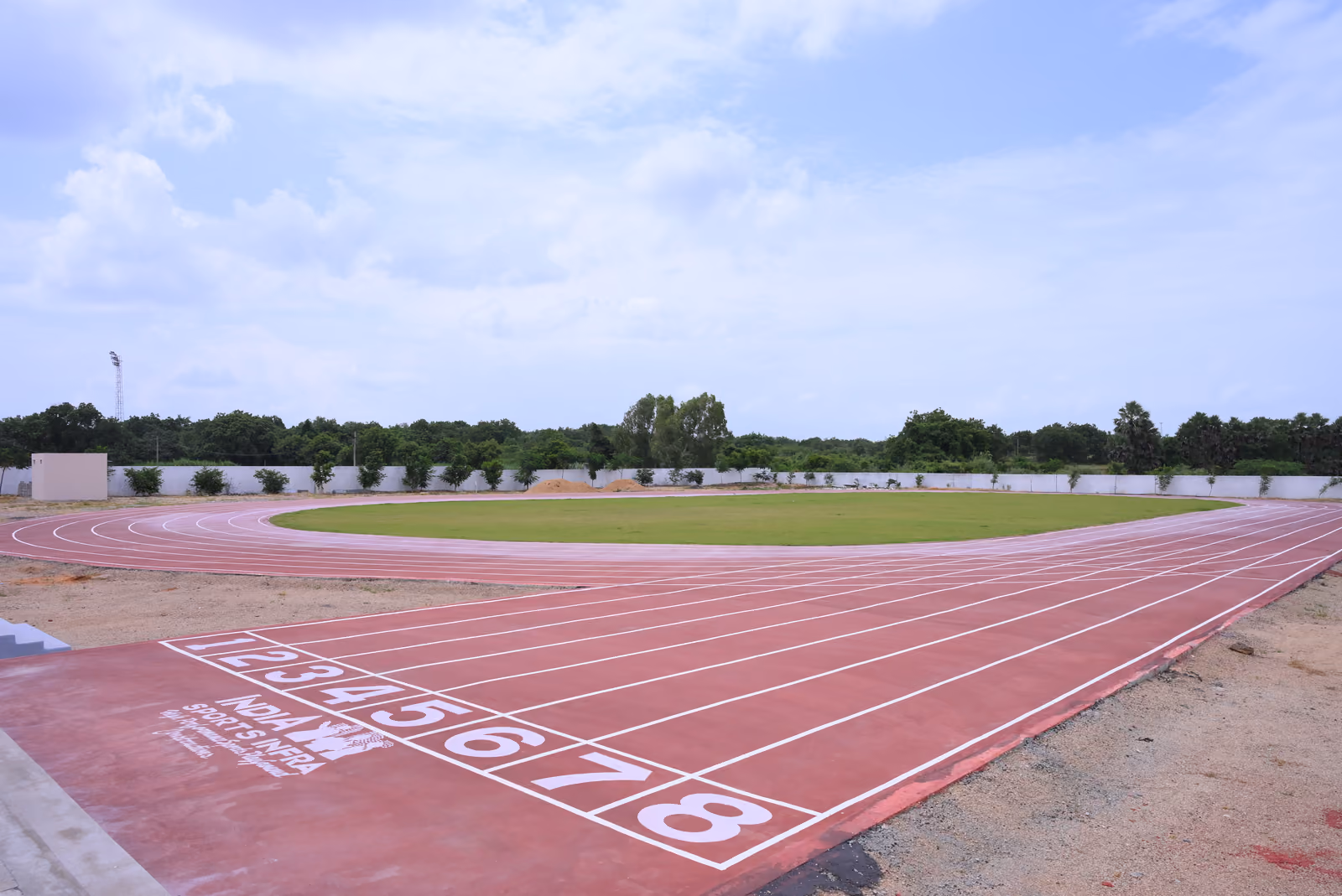 Eight-lane synthetic running track starting line around a grass field